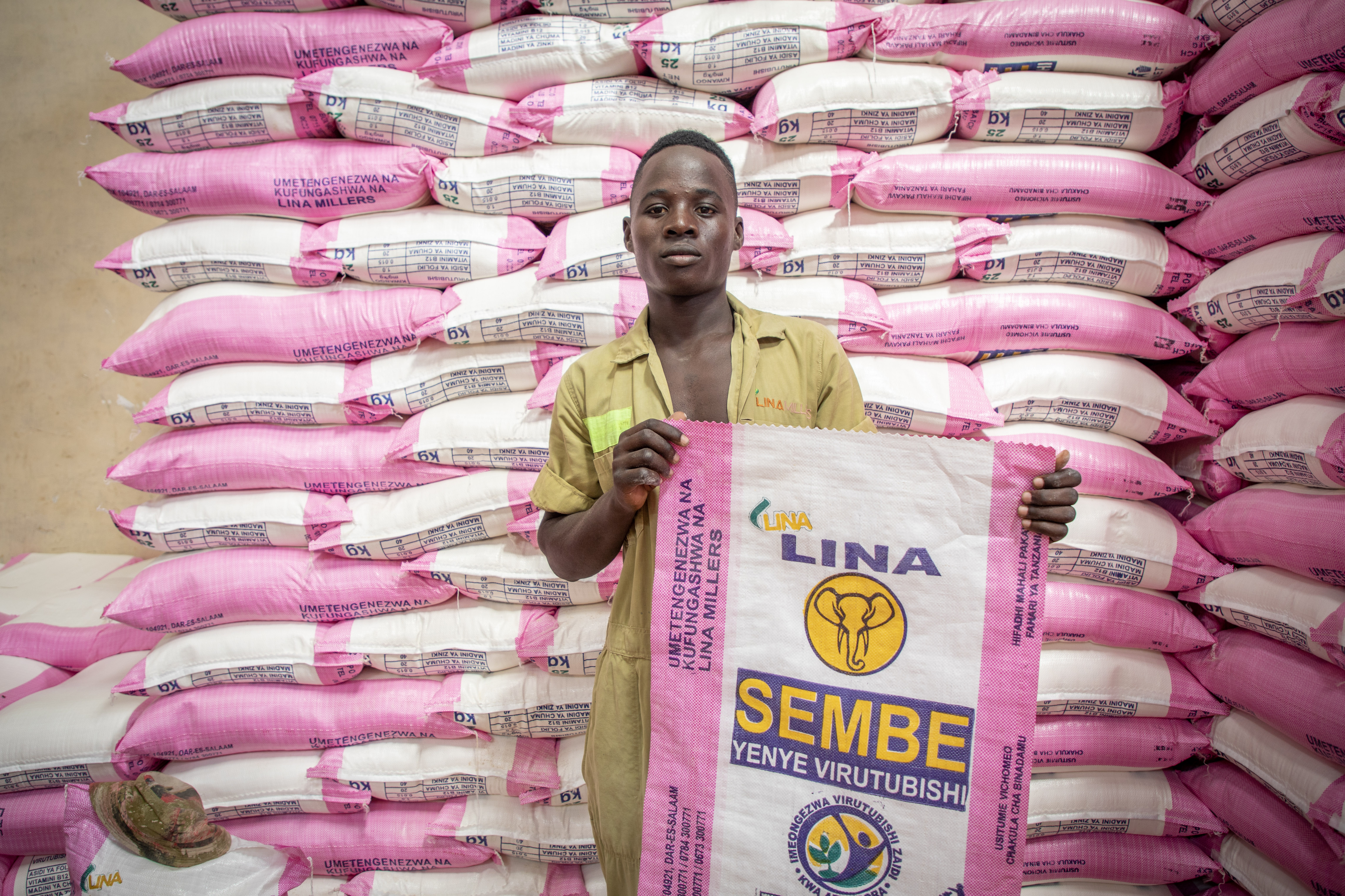 A man holding a bag of grains.