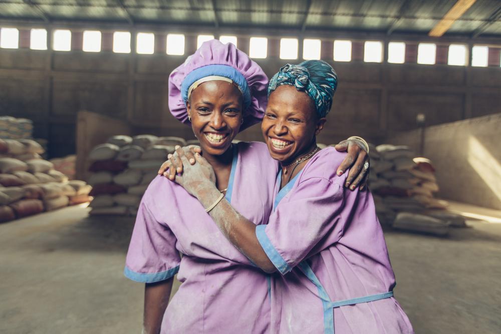 two women hugging at milling facility 