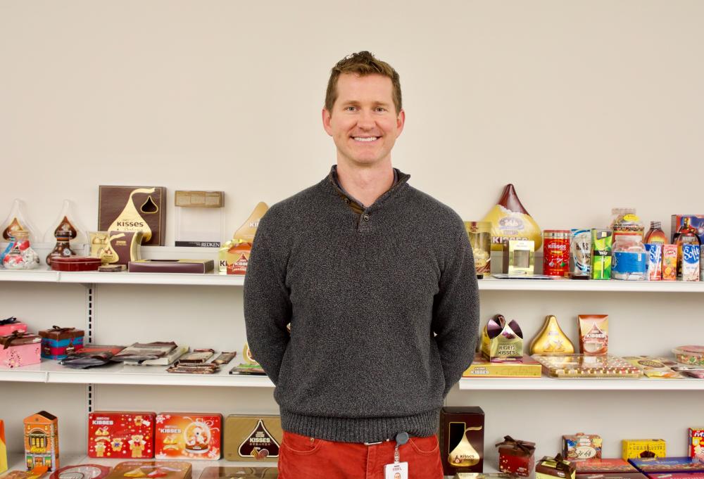 Joel Farmer standing in front of packaging 