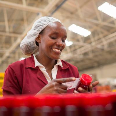 Woman applying label to jam jar