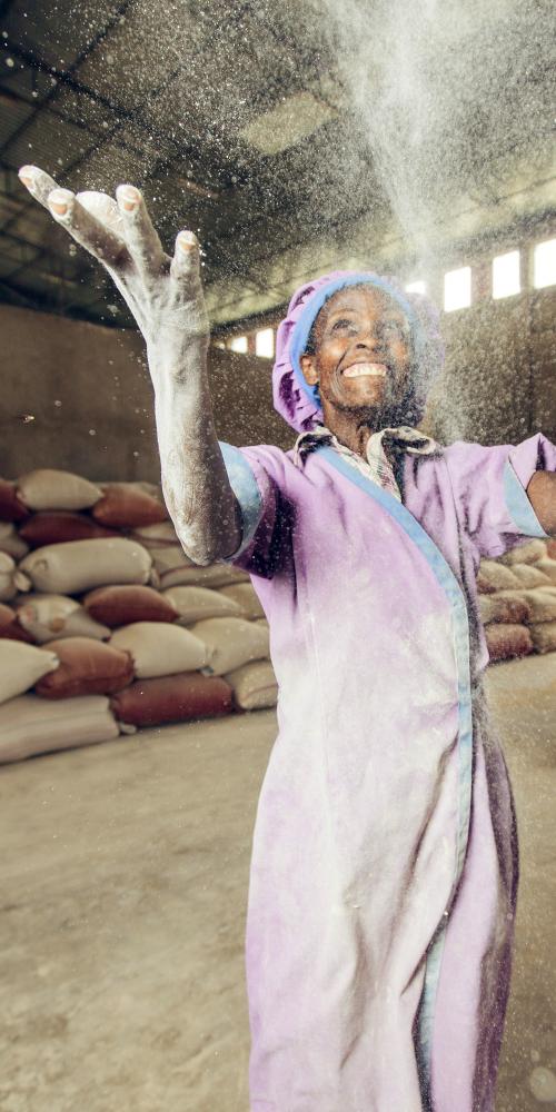 Woman in Ethiopia tossing flour in the air.